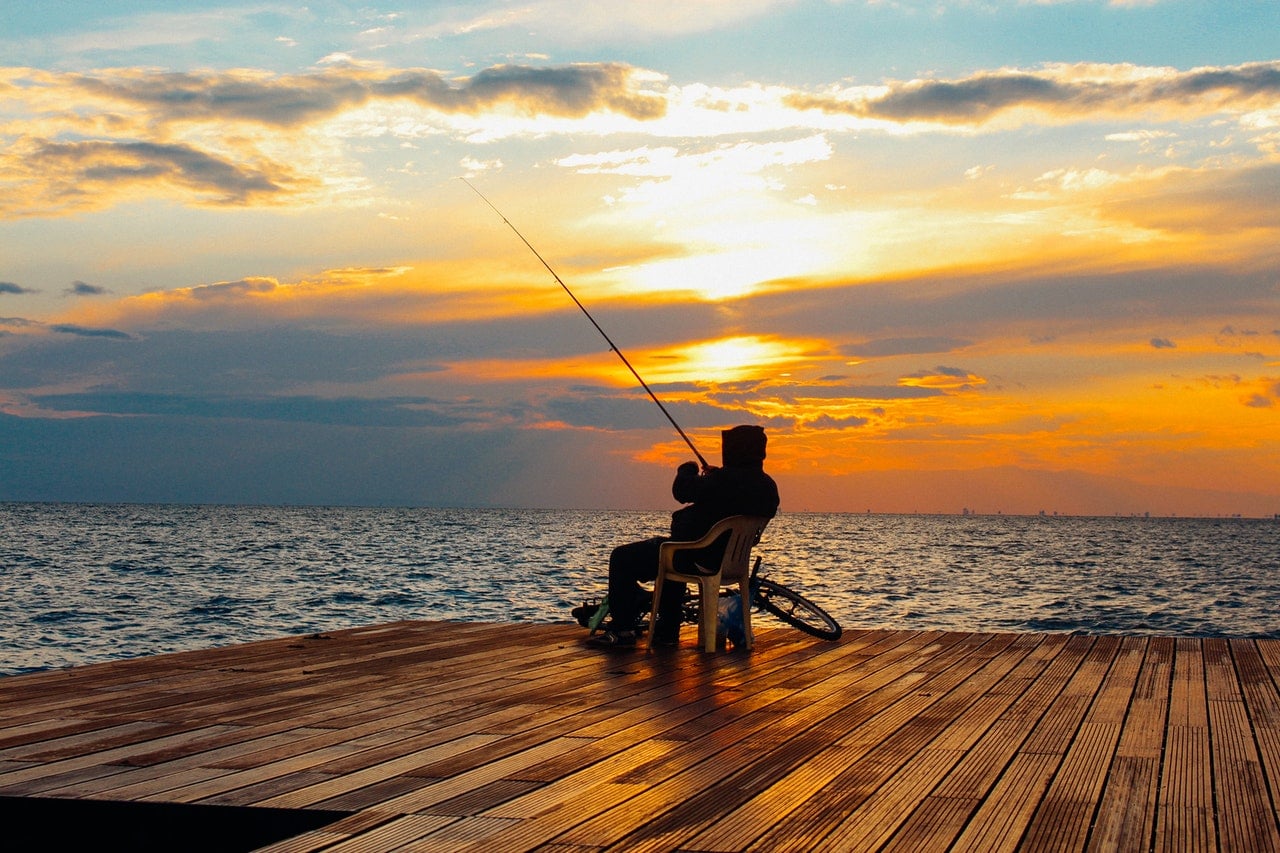 man sitting on a pontoon fishing