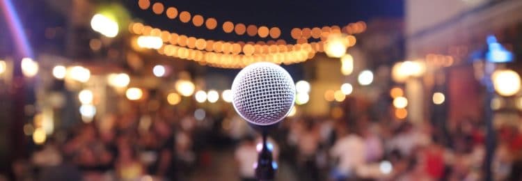 close up of microphone with blurred out audience in the background